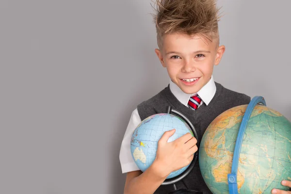 Vrolijk lachende kleine jongen op een grijze achtergrond. School concept — Stockfoto