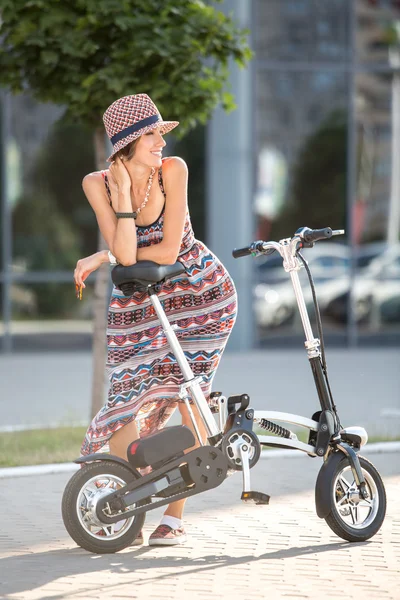 Femme sur un vélo en ville par une journée ensoleillée — Photo