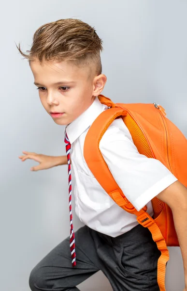 Schuljunge mit orangefarbener Tasche läuft zur Schule — Stockfoto