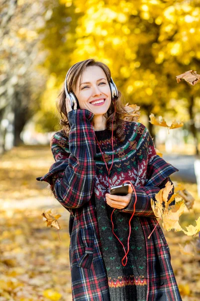 Gyönyörű lány, hallgató-hoz zene őszi sárga Park — Stock Fotó
