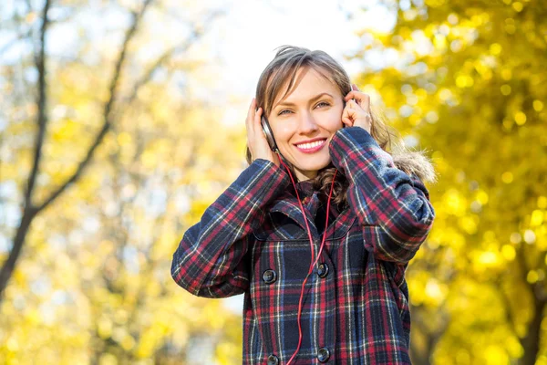 Belle fille écoutant de la musique en automne jaune parc — Photo