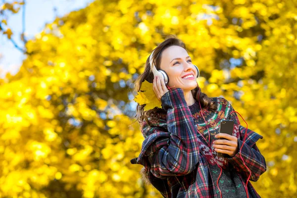 Belle fille écoutant de la musique en automne jaune parc — Photo