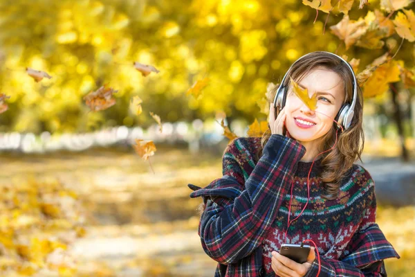 Belle fille écoutant de la musique en automne jaune parc — Photo