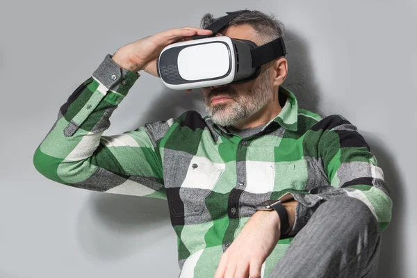 Mannen i virtual reality-glasögon över grå vägg bakgrund — Stockfoto