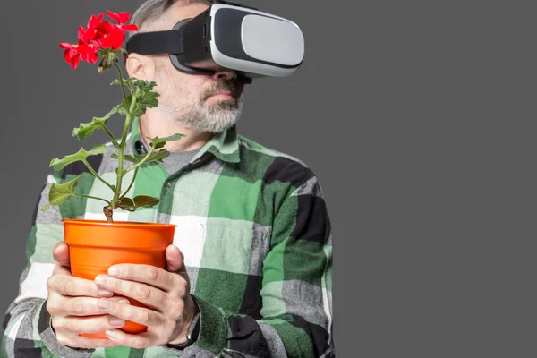 Man hålla blommor och bär virtual reality-glasögon — Stockfoto