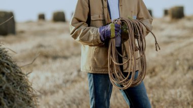 Tarladaki çiftçi şapka ve iş kıyafetleri giyiyor.