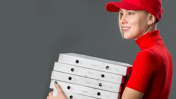 送货女工身穿红帽 空白T恤衫制服 将食品定单披萨盒隔离在灰色背景工作室里 — 图库照片