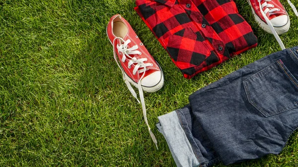 青赤白の草の上に置かれたカジュアルな服 — ストック写真