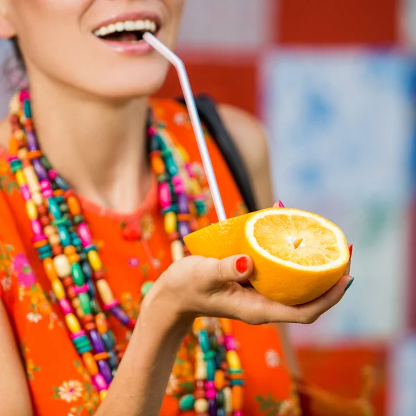 Moda mulher bebendo suco de laranja sorrindo — Fotografia de Stock