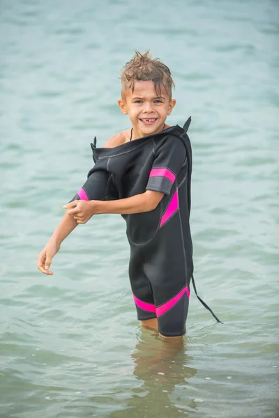 Menino bonito em roupa de mergulho depois de mergulhar no mar — Fotografia de Stock