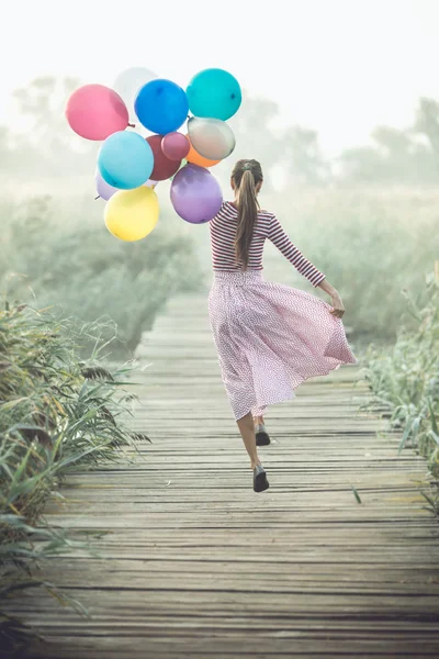 Belle femme avec des ballons colorés — Photo