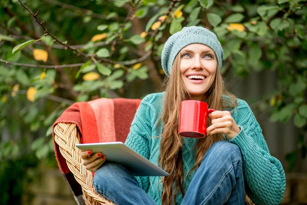 Hermosa mujer con té caliente usando tableta — Foto de Stock