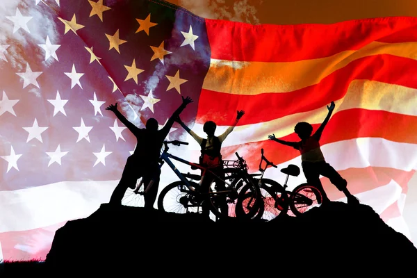 Ciclismo familia americana al atardecer cielo fondo — Foto de Stock