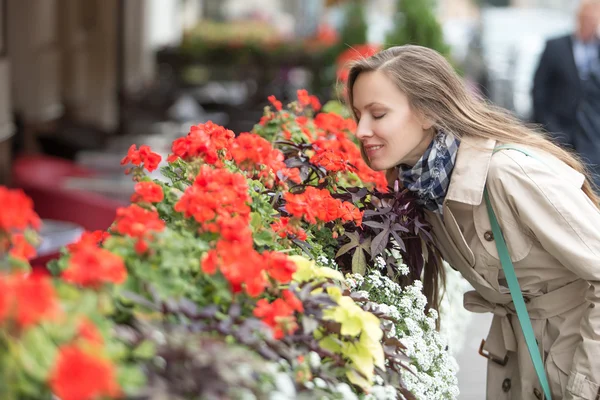 Vacker ung kvinna luktar blommor — Stockfoto