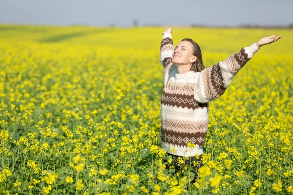 Jovem mulher no campo de flores e céu — Fotografia de Stock