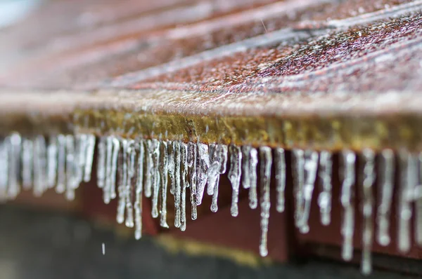 Eiszapfen hängen von einem Dach herunter — Stockfoto