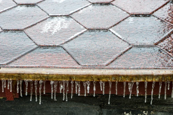 Eiszapfen hängen von einem Dach herunter — Stockfoto