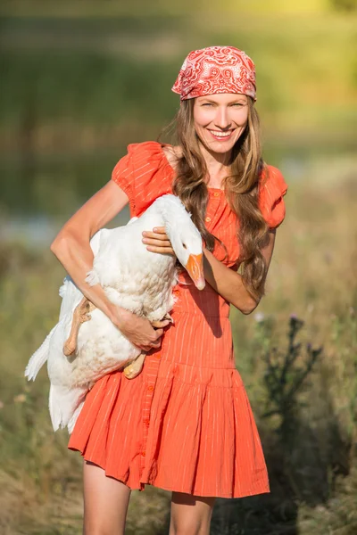 若い農家の女性が白いガチョウを保持します。 — ストック写真
