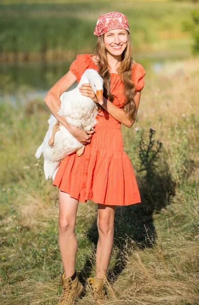 Mujer agricultora joven sostiene ganso blanco —  Fotos de Stock