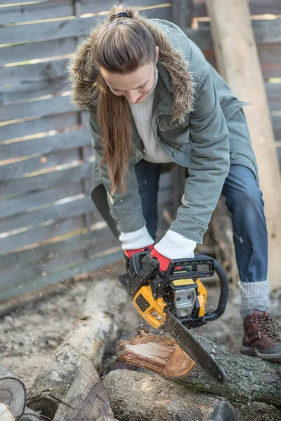 Beautiful female woodworker with chainsaw — Stock Photo, Image