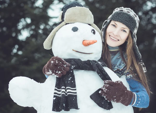 Retrato de mujer divertida de invierno con muñeco de nieve —  Fotos de Stock