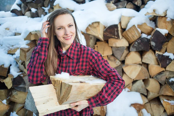 Young woman posing with wooden logs for bonfire — Stock Photo, Image