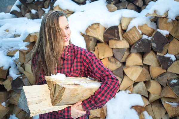 Young woman posing with wooden logs for bonfire — Stock Photo, Image