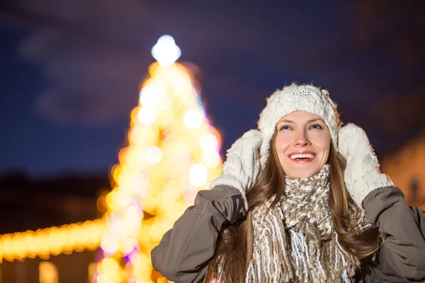 Portret van lachende jonge vrouw in de buurt van de kerstboom — Stockfoto