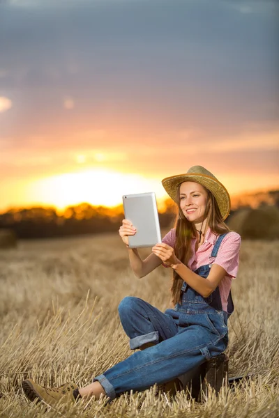 Woman using tablet pc outdoor over sunset — Stock Photo, Image