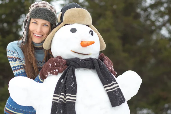 Mujer divertida con muñeco de nieve — Foto de Stock