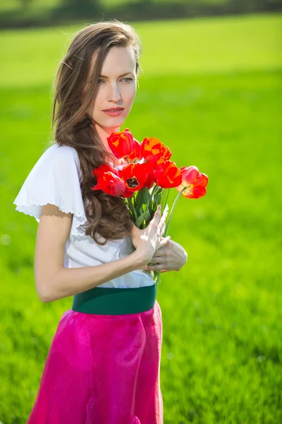 Frau mit Frühlingsblumen — Stockfoto