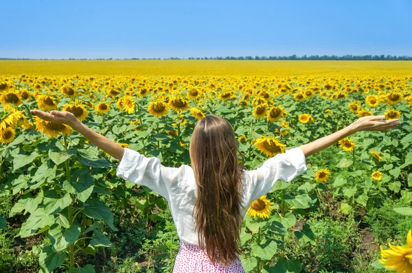 Donna con le braccia distese in un campo — Foto Stock