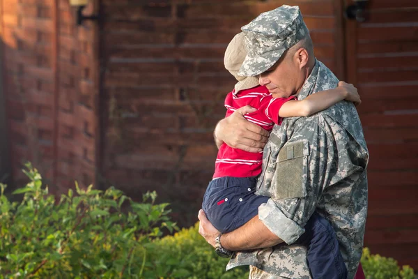 军人的父亲抱着儿子 免版税图库照片