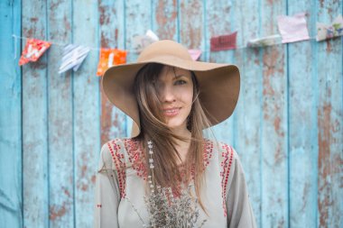 Şapka mavi ahşap duvar karşı olan kadın