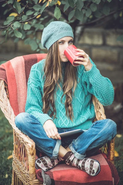 Schönes Mädchen ruht sich im herbstlichen Garten aus — Stockfoto