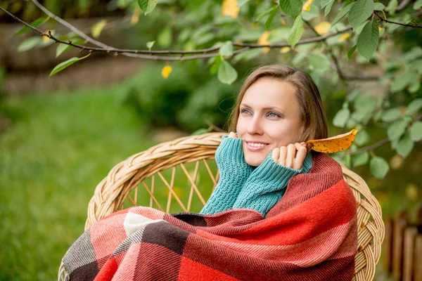 Schönes Mädchen ruht sich im herbstlichen Garten aus — Stockfoto