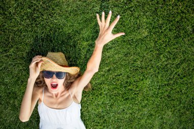 mutlu genç kadın yeşil çim üzerinde yalan