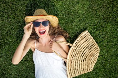 mutlu genç kadın yeşil çim üzerinde yalan