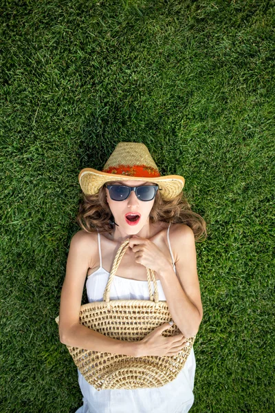 Счастливая молодая женщина лежит на зеленой траве и мечтает. пространство для копирования, вид сверху — стоковое фото