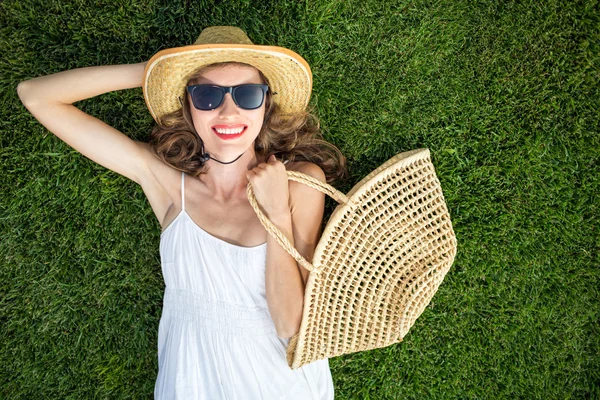 Mujer joven y feliz tumbado en la hierba verde, concepto de comprador feliz —  Fotos de Stock