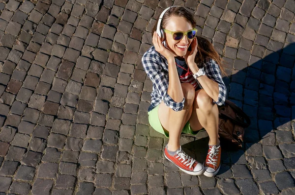 Joven sentada disfrutando escuchando música — Foto de Stock