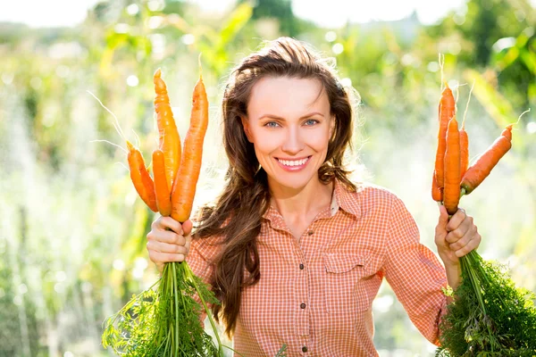 Bella giovane donna con carote biologiche — Foto Stock