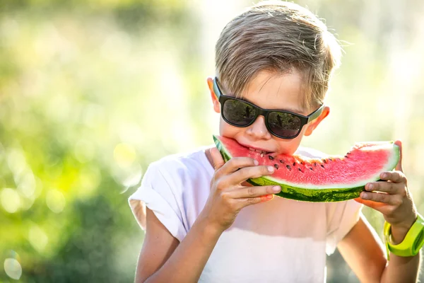 Legrační dítě jíst meloun venku — Stock fotografie