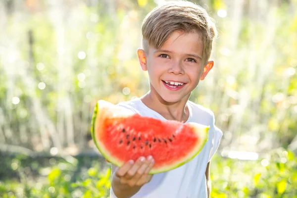 Funny kid eating watermelon outdoors