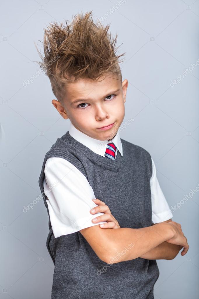 Cute little boy wearing white shirt, tie and grey vest, fashion look