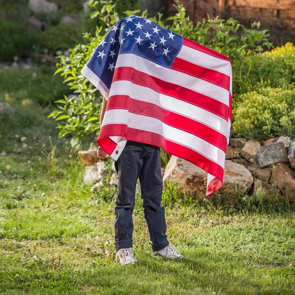 Zadowolony ładny chłopczyk z amerykańską flagę — Zdjęcie stockowe