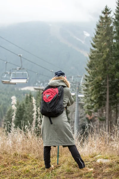 Traveler standing over mountain and empty ski lifts — Stock Photo, Image