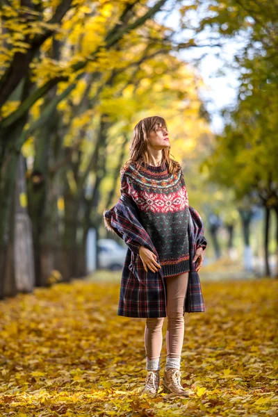 Jonge vrouw permanent in herfst alley weg — Stockfoto