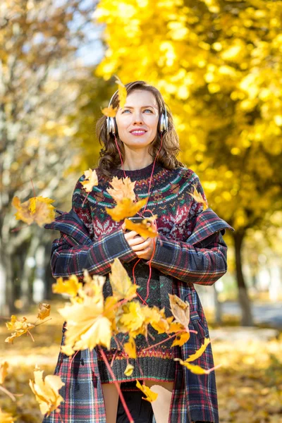 Belle fille écoutant de la musique dans le parc d'automne — Photo