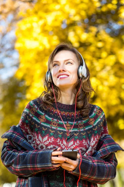 Hermosa mujer de otoño escuchando música en el parque dorado de otoño —  Fotos de Stock
